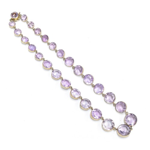 12 - An early 20th century silver and amethyst riviere necklace, the amethysts in gilded silver bezel set... 