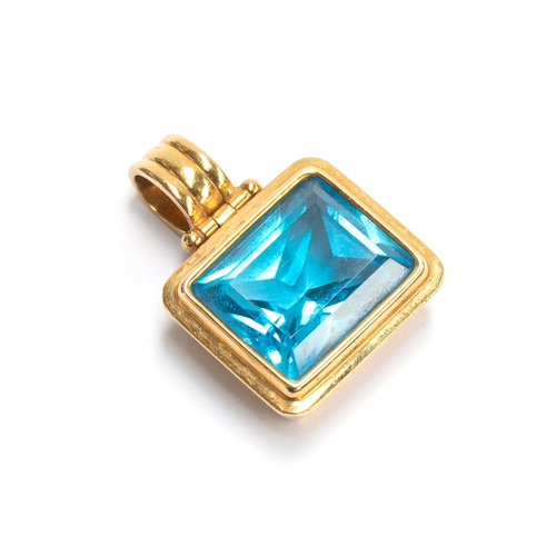 30 - A contemporary 18ct gold and blue topaz pendant on a black rubber cord with an 18ct gold clasp, the ... 