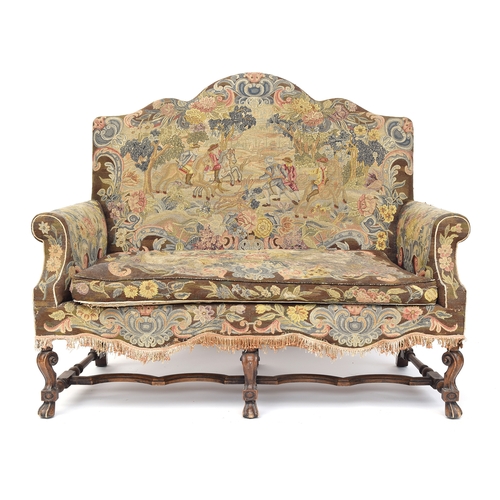 454 - A Queen Anne style two seater sofa, needlework upholstery, the shaped back over outscrolled arms, on... 