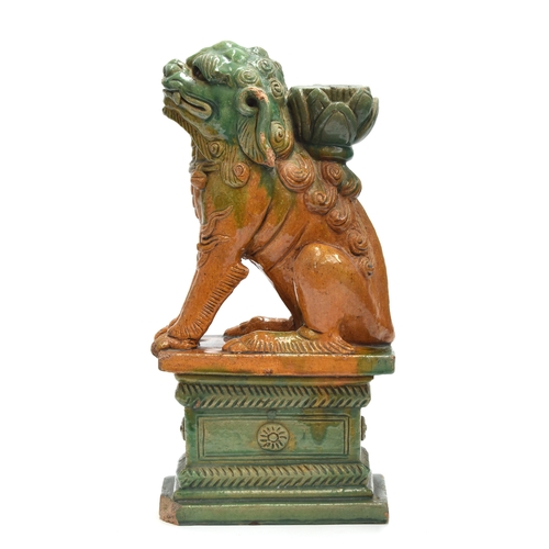 200 - A Chinese Kangxi style sancai glazed joss stick holder modelled as a foo dog on a rectangular plinth... 