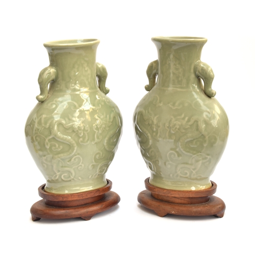 202 - A pair of Chinese Longquan celadon glaze dragon vases with twin Elephant lug handles, 27cm high, 19.... 