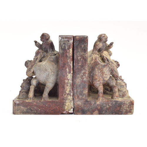 204 - A pair of heavy Chinese carved soapstone bookends in the form of a young girl riding a buffalo, each... 