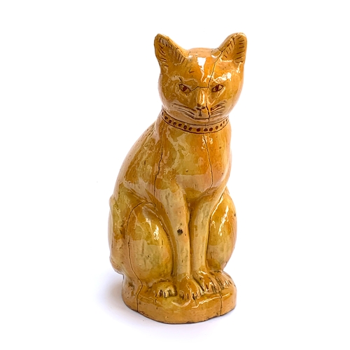 67 - A Welsh Claypits Ewenny pottery seated cat c.1900, in mustard glaze with incised detail, firing faul... 