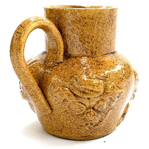 101 - An unusual small stoneware jug moulded with Louis Wain style cartoon cat and dog faces, 7cm high