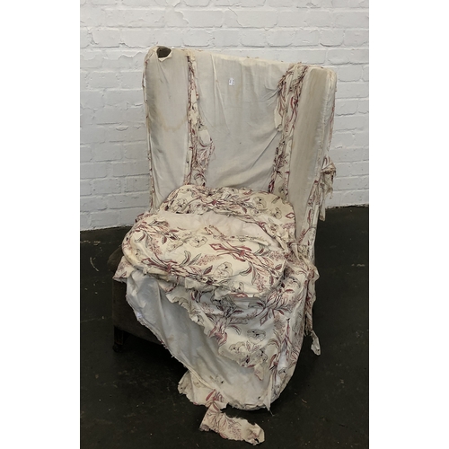 878 - A 20th century wingback armchair in need of reupholstery