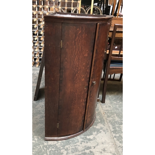 823 - An George III oak bowfront mahogany corner cupboard with three shelves, 96cmH