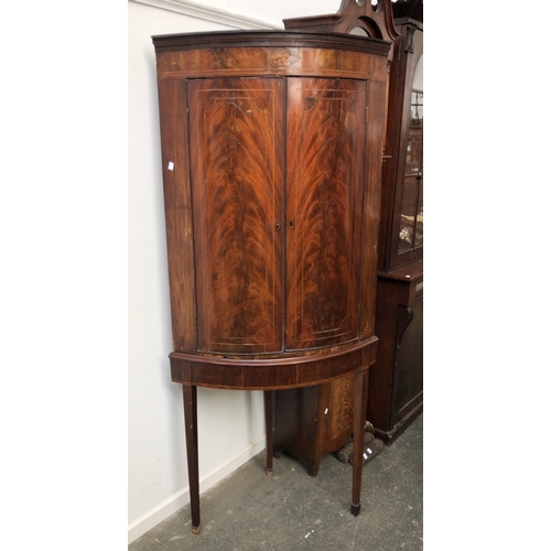 868 - A George III mahogany standing bowfront corner cupboard, with two shelves, the base on square line-i... 