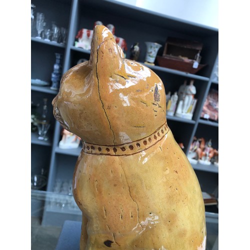 67 - A Welsh Claypits Ewenny pottery seated cat c.1900, in mustard glaze with incised detail, firing faul... 