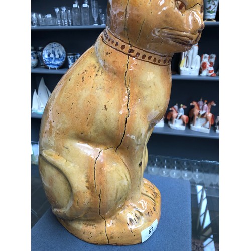 67 - A Welsh Claypits Ewenny pottery seated cat c.1900, in mustard glaze with incised detail, firing faul... 