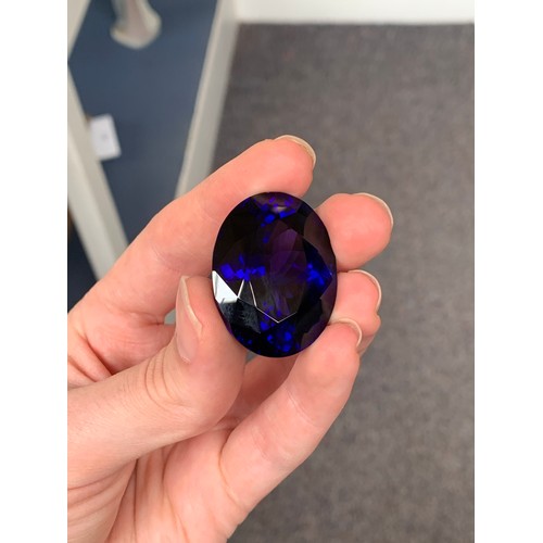 110 - An exceptional unmounted tanzanite weighing 135cts, oval modified brilliant cut, accompanied with IG... 