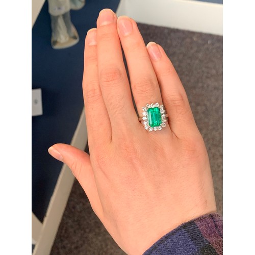 32 - A platinum mounted emerald and diamond cluster ring, the Boyaca Columbian emerald weighing 5.75cts a... 