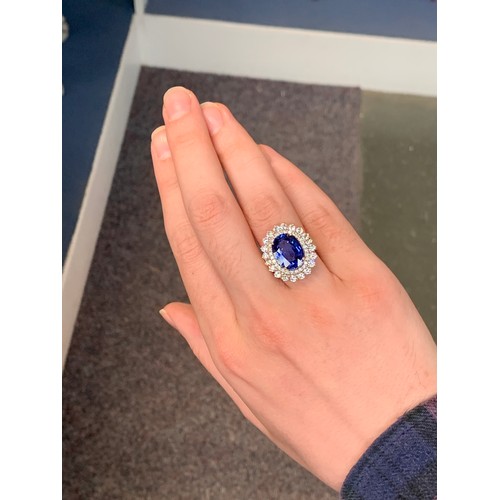 31 - An 18ct gold sapphire and diamond cluster ring, the large Sri Lankan sapphire 14x10mm weighing appro... 