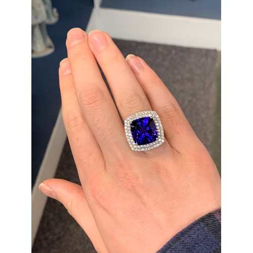 35 - A platinum mounted tanzanite and diamond cluster ring, the large cushion cut tanzanite measuring app... 