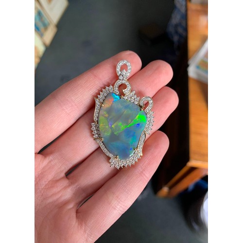 86 - An 18ct gold mounted lightning ridge black opal and diamond pendant, the opal 24.19cts, the diamonds... 