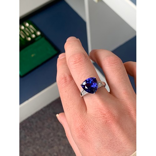 104 - A platinum, tanzanite and diamond ring, the trillion cut tanzanite 7.5cts and 12mm wide, diamonds to... 