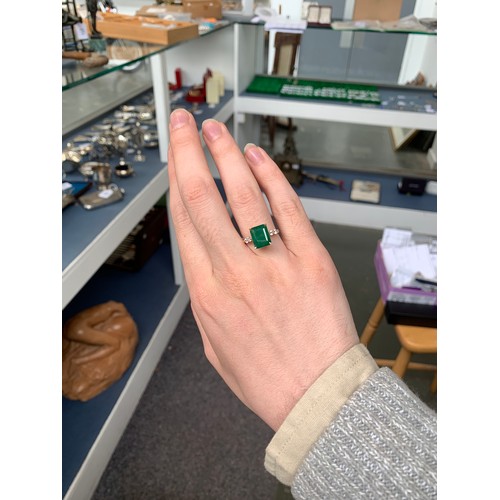 41 - An 18ct gold ring set with an emerald and white sapphires, the Bahia emerald 4.4cts and 11x8.5mm, th... 