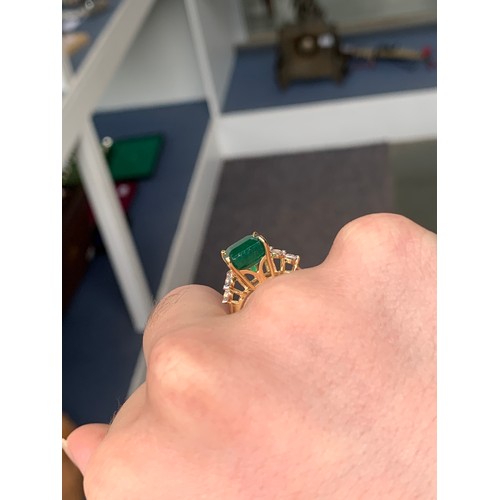 41 - An 18ct gold ring set with an emerald and white sapphires, the Bahia emerald 4.4cts and 11x8.5mm, th... 