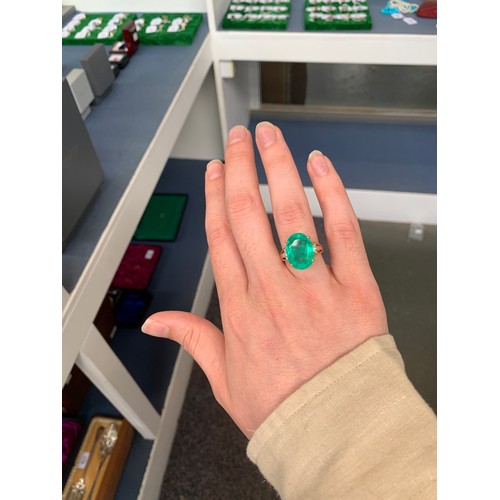 38 - An impressive 18ct gold ring set with a large Muzo Colombian emerald, the oval cut emerald 17x12mm a... 