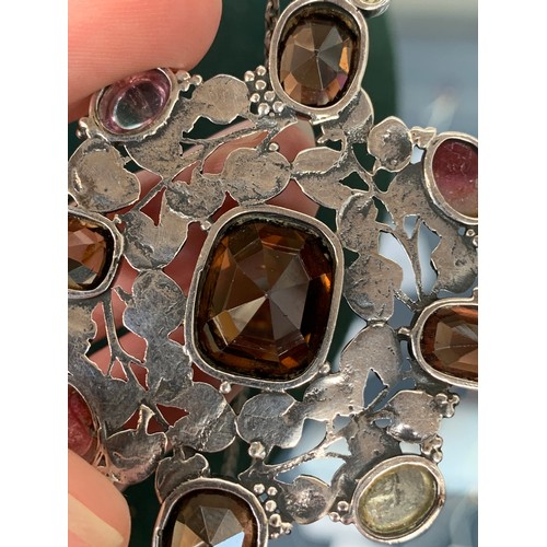 21 - Attributed to Amy Sandheim, a c.1920s Arts and Crafts silver gem set pendant, the openwork silver in... 