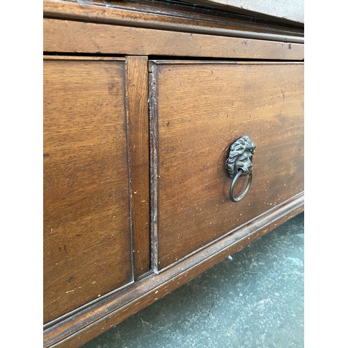 380 - A George III mahogany dwarf linen press, the panelled doors opening to four slides, over two drawers... 