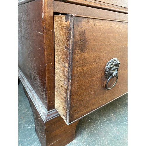 380 - A George III mahogany dwarf linen press, the panelled doors opening to four slides, over two drawers... 