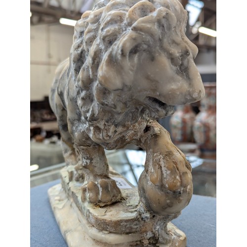 234 - A pair of carved marble sculptures in the form of Medici lions with orbs, 24cm long

Provenance: pri... 