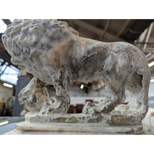 234 - A pair of carved marble sculptures in the form of Medici lions with orbs, 24cm long

Provenance: pri... 