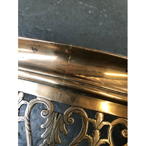 351 - A George III serpentine brass fender, c.1800, the pierced front with scroll and trailing bell flower... 