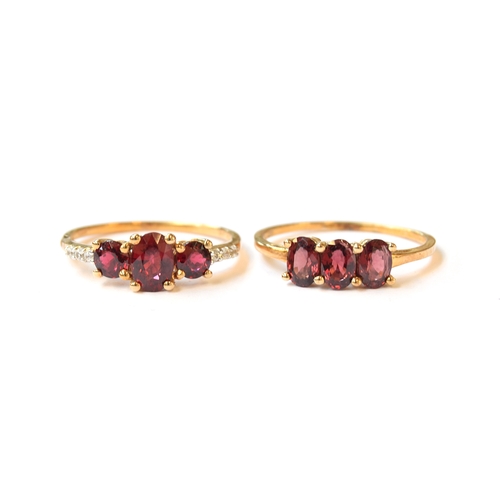 39 - Two 9ct gold Burmese red spinel trilogy rings, one set with white zircons, both size U, gross weight... 