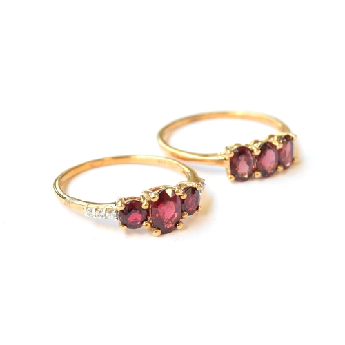 39 - Two 9ct gold Burmese red spinel trilogy rings, one set with white zircons, both size U, gross weight... 