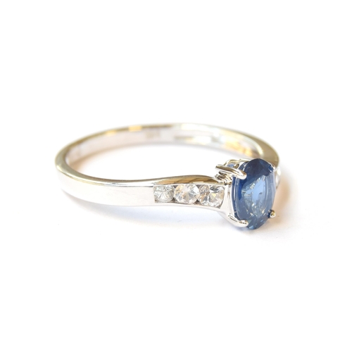 54 - A 14ct white gold ring set with a sapphire and three channel set white sapphires, the blue Kanchanab... 