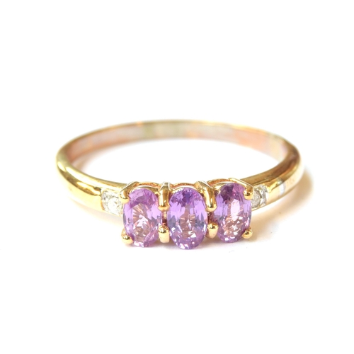 55 - A 9ct gold purple sapphire and diamond trilogy ring, the purple ceylon sapphires totalling 0.9cts, s... 