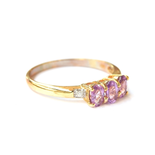 55 - A 9ct gold purple sapphire and diamond trilogy ring, the purple ceylon sapphires totalling 0.9cts, s... 