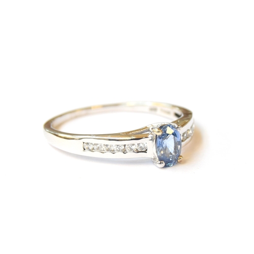 61 - A 9ct white gold ring set with a ceylon sapphire and natural white zircons, the sapphire 0.62cts, si... 