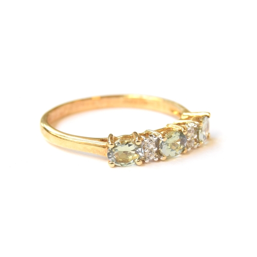 64 - A 9ct gold ring set with green tanzanites and white zircons, the tanzanites totalling 0.97cts, size ... 