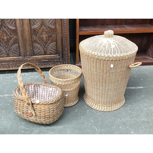 657 - A wicker lidded laundry basket; together with two other small baskets