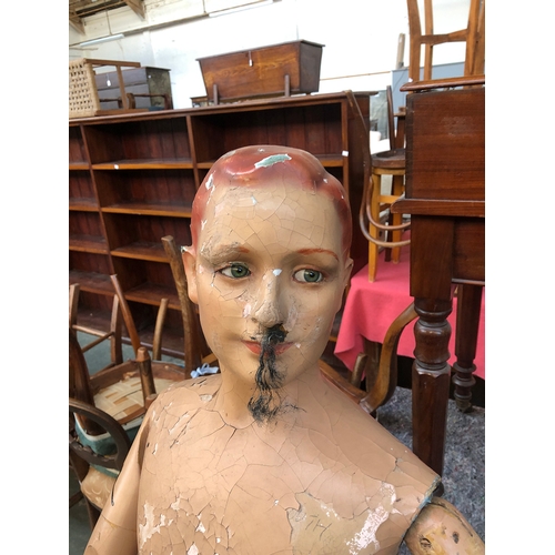 679 - An early 20th century shop display mannequin with articulated arms and detailed glass eyes, 150cmH