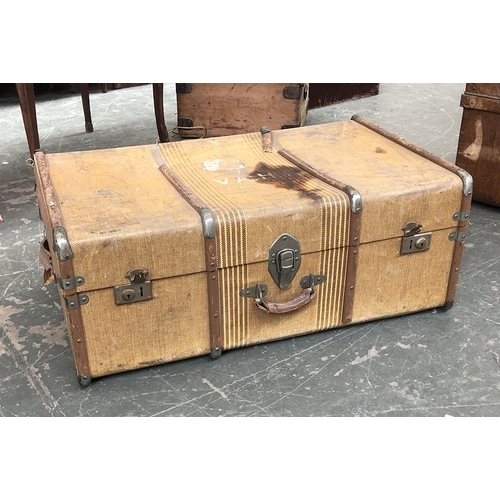 736 - A canvas and wood banded travel trunk; together with two large metal travel trunks, the larger 90cmW