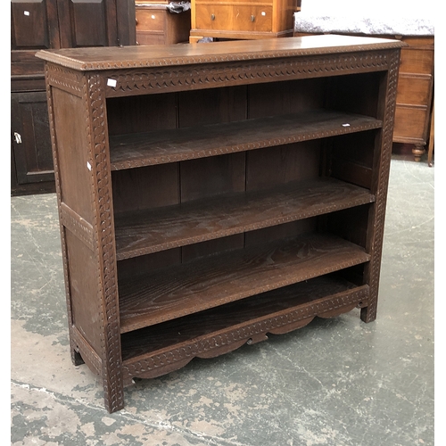 757 - A carved oak bookcase with three adjustable shelves, 120cmW