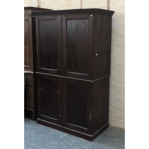 813 - A 19th century stained pine cupboard, panelled doors, the top with two slides, the base subdivided w... 