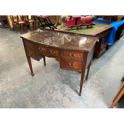 784 - An Edwardian mahogany bowfront dressing table, with five drawers surrounding a kneehole, on square t... 