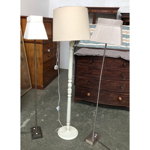 625 - Two brushed metal standard lamps; with a white painted standard lamp (3)