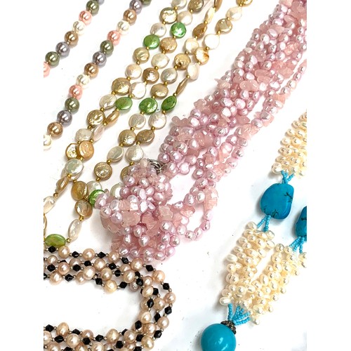 47 - A quantity of mainly coloured cultured pearl necklaces, some multi-strand, to include green, pink, b... 