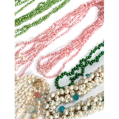 47 - A quantity of mainly coloured cultured pearl necklaces, some multi-strand, to include green, pink, b... 