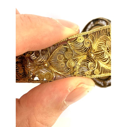 63 - A Victorian silver gilt filigree bracelet with canetille detail, set with a central carved pink conc... 