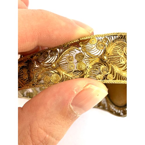 63 - A Victorian silver gilt filigree bracelet with canetille detail, set with a central carved pink conc... 