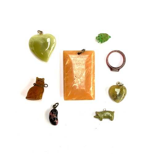 66 - A carved bakelite ring and rectangular pendant; a moss opal heart pendant; a Czech glass cat; lucky ... 