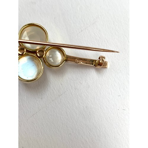 73 - An Edwardian 9ct gold bar brooch set with four bezel set moonstone bullet cabochons interspersed wit... 