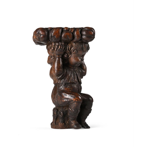 124 - An 18th century carved oak figural column capital, modelled as a seated youth supporting the platfor... 