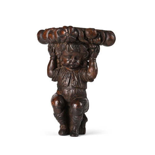 124 - An 18th century carved oak figural column capital, modelled as a seated youth supporting the platfor... 